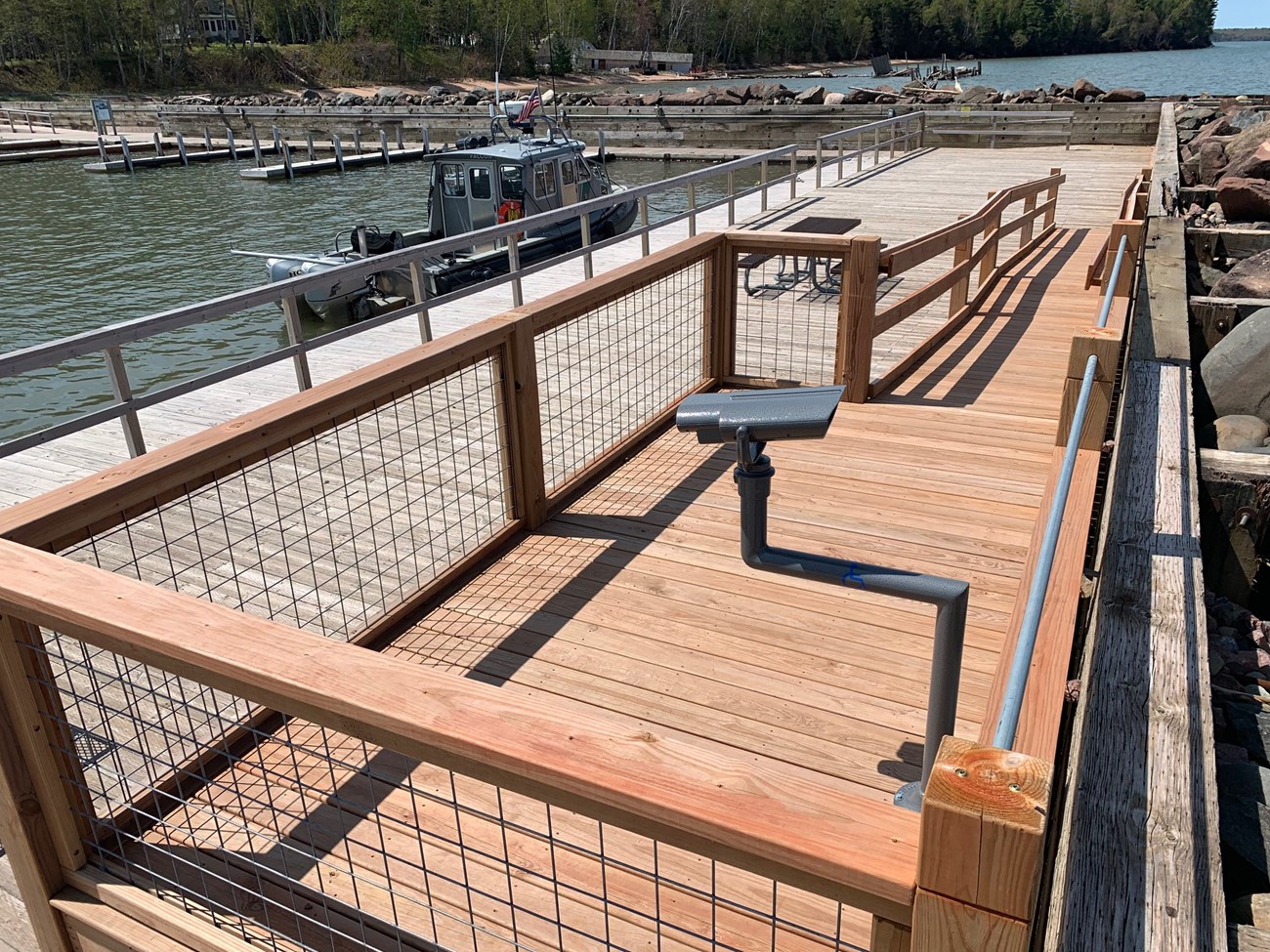 A wooden viewing platform with binoculars on the dock.