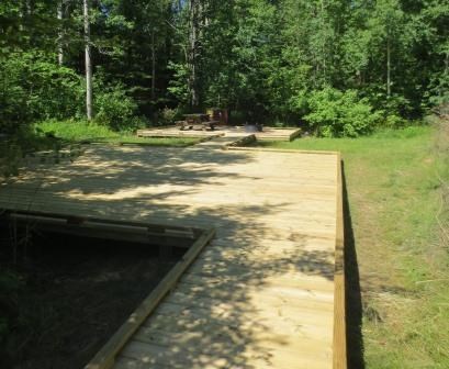 Sand Island, campsite 4 with wooden deck tent pad, bear locker, fire ring, and picnic table.