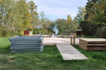 Sand Island, campsite C, with wooden deck tent pad, fire pit, picnic table, and bear locker.