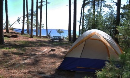Tent on the tent pad at campsite twelve on Stockton Island, with Lake Superior in the background.
