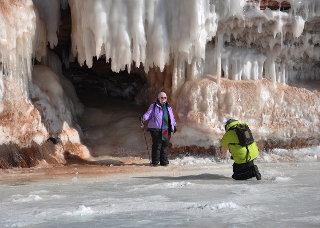 Photograph of visitors taking a photo in front of ice formations.