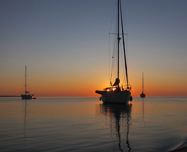 A sailboat on the lake at sunset.