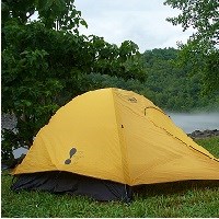 A yellow tent in a wooded setting.