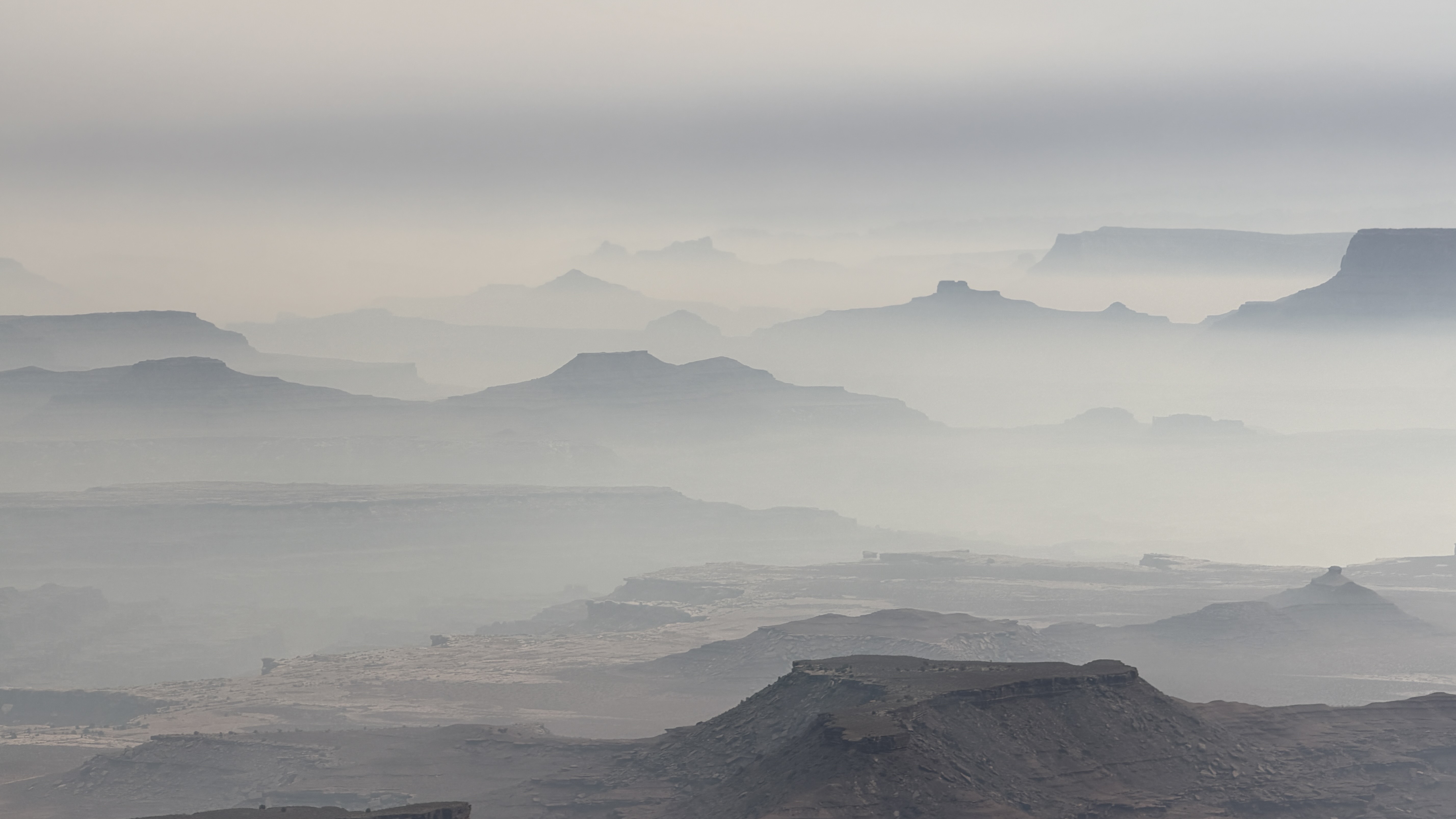Wildfire smoke blankets a canyon landscape