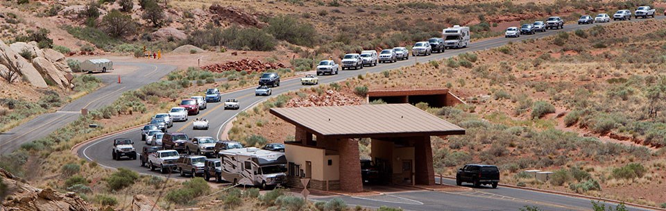 Two lanes of traffic lined up and waiting at the entrance station.