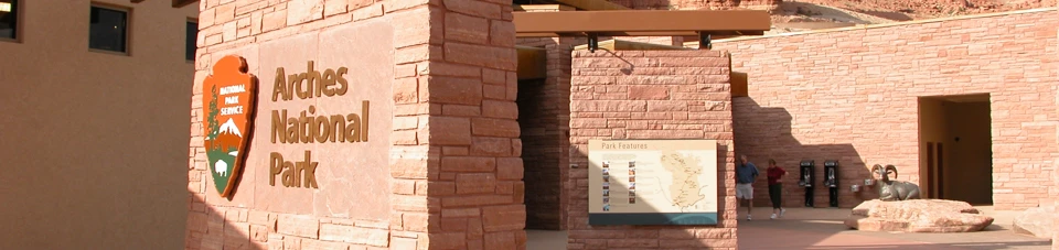Arches National Park Visitor Center brick building structures with a sign reading Arches National Park