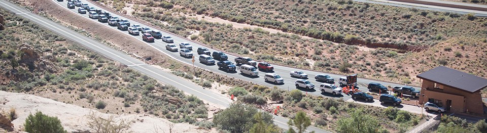 a line of cars in front of a small building