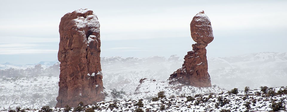 two red rock pinnacles in a snowy landscape