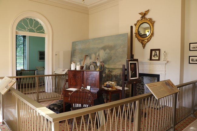 A large room with furniture and paintings and an art studio.
