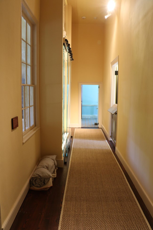 A hallway in Arlington House with a rolled up bed.