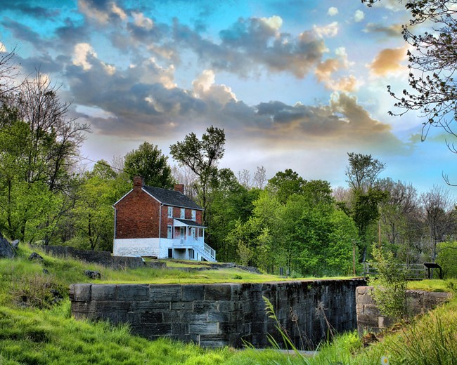 Lockhouse 49 A three story, brick lockhouse surrounded by lush trees