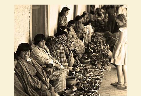 Pueblo Indians selling pottery and jewelry on portal, Palace of the Governors, Santa Fe, New Mexico, c. 1925-1945. Photo Credit: Photographer unknown. Courtesy of the Palace of the Governors Photo Archives (NMHM/DC. Neg.#0699735)