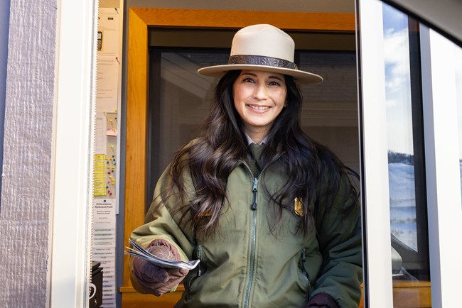 Enjoy the Drive A park ranger hands a map out of a window at an entrance station.