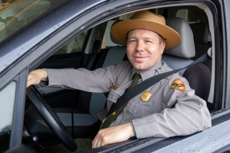 Enjoy the Ride a park ranger sitting in a car