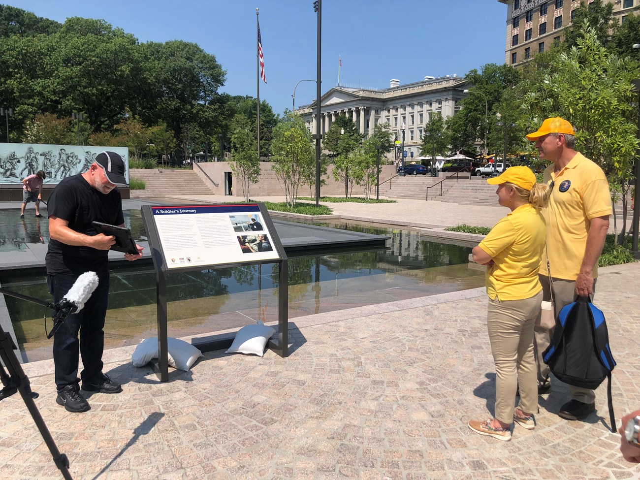 Theo Mayer from the U.S. World War One Centennial Commission/Doughboy Foundation demonstrates virtual interpretation functions on an iPad for volunteers at the newly redesigned World War I Memorial also known as Pershing Square.