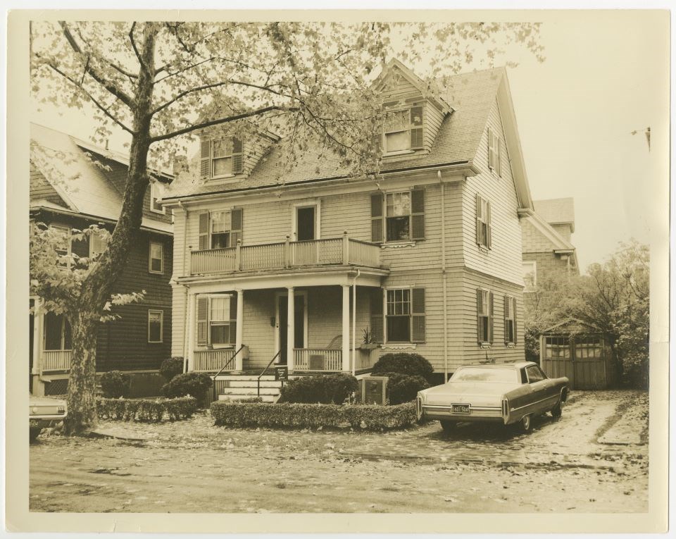 Sepia photo of 83 Beals St. Driveway and car to right of home.