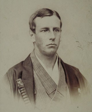 Young white man in head-and-shoulders portrait, wearing kimono