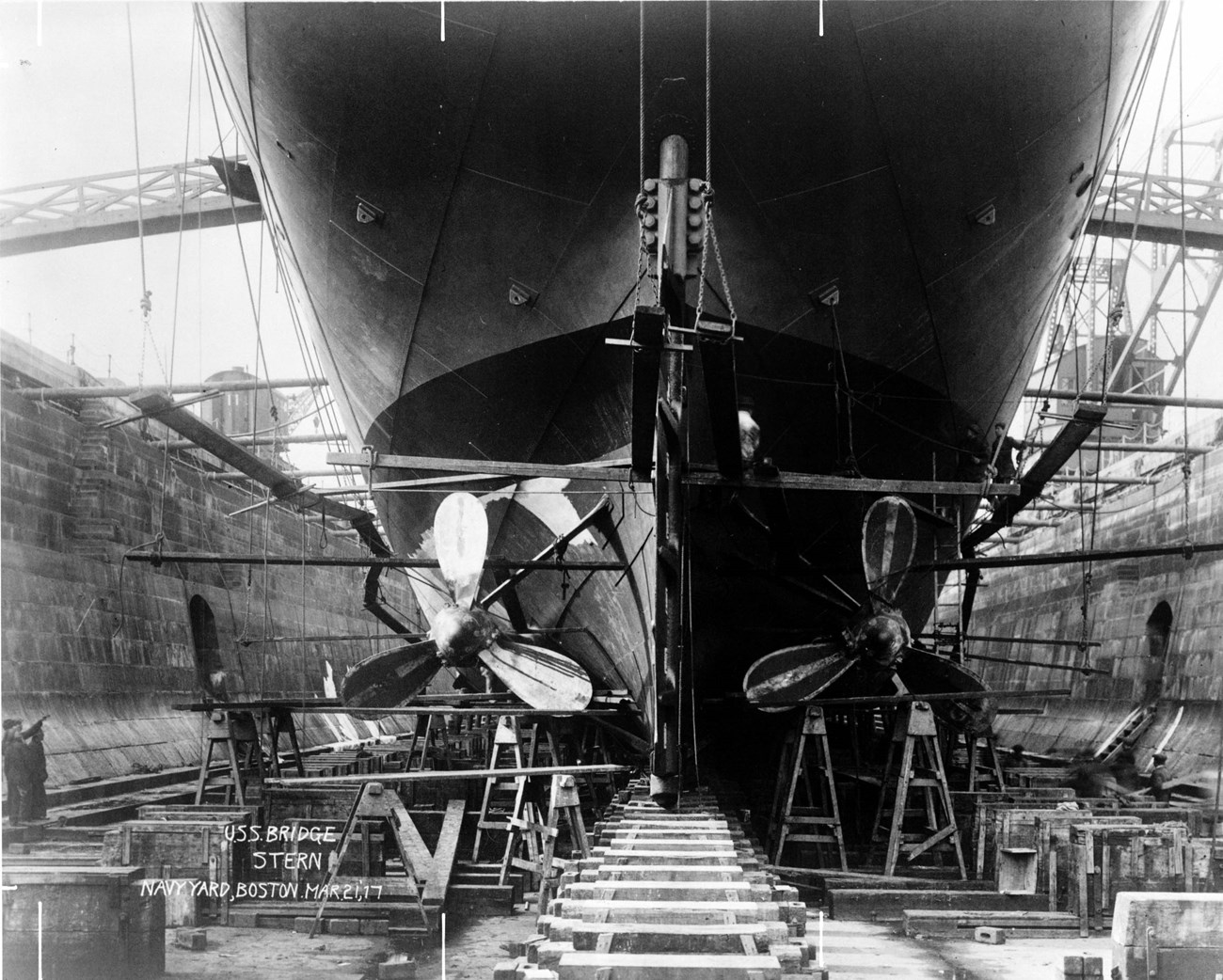 View of propellers of supply ship USS BRIDGE while it is in a dry dock.