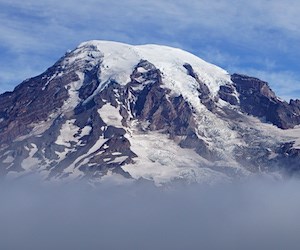 Mount Rainier A glaciated mountain peak rising above a layer of clouds.