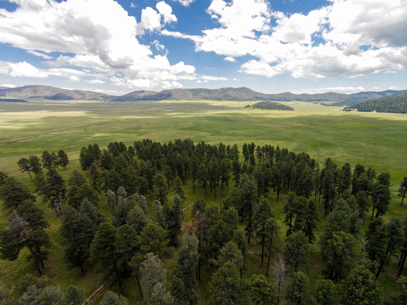 photo of an open valley with mountains in the distance