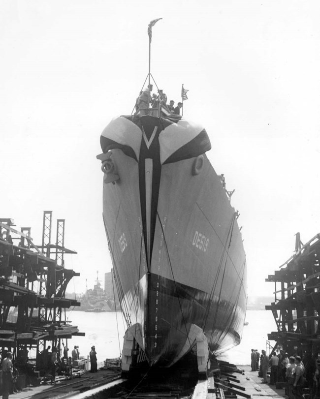 Destroyer escort DE519 being launched from a shipway into the harbor.