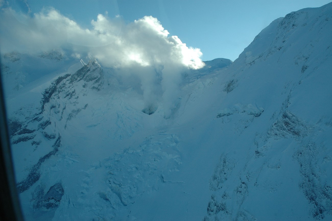 steaming fumaroles on a snow covered mountain