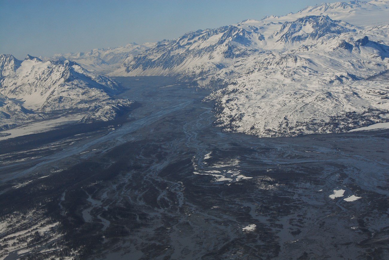 river valley filled with sediment and snowy peaks