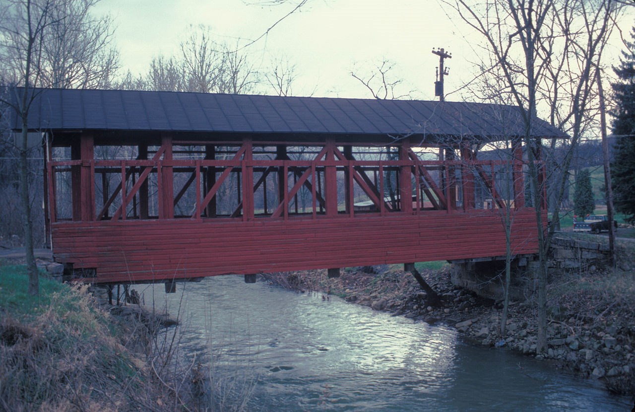 FISCHTNER COVERED BRIDGE Red covered bridge over a body of water.