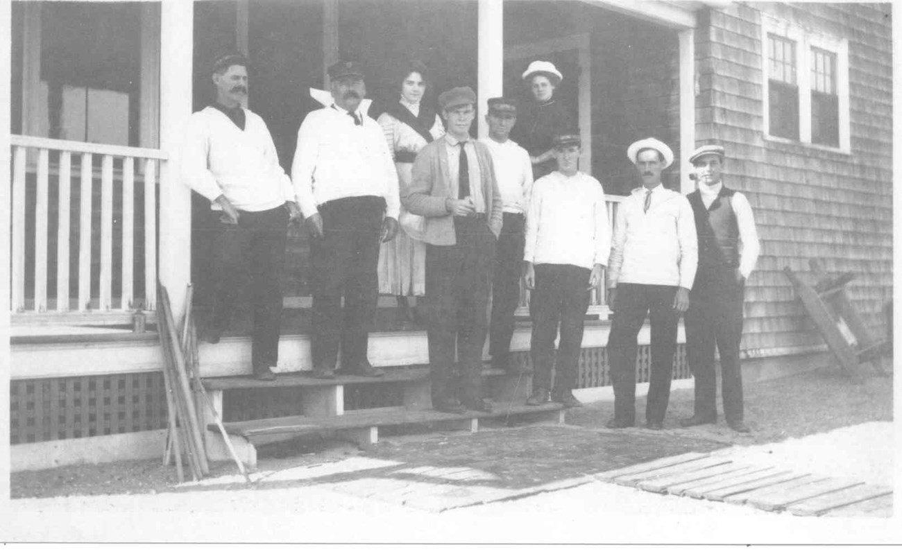 Life-Saving Station crew and family members a group of men and women standing on a porch