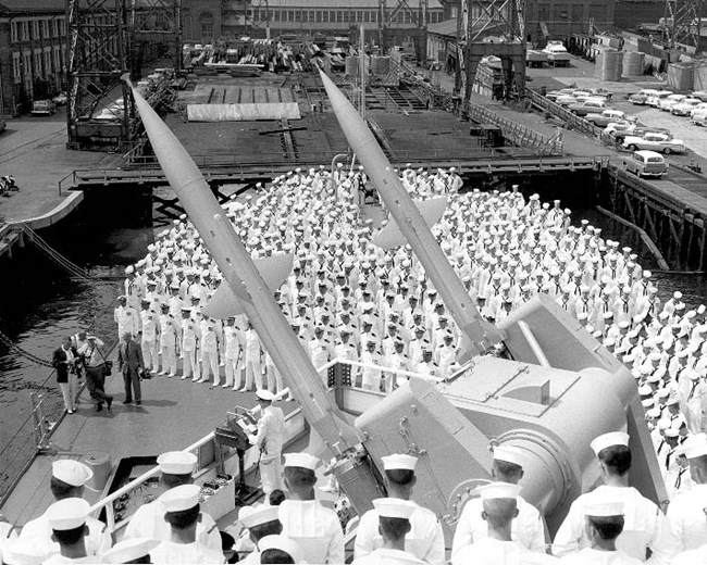 crew in formal dress line the deck of a ship