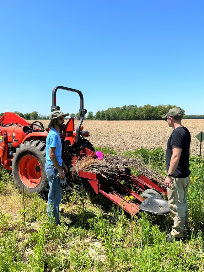 Two people with tractor in field