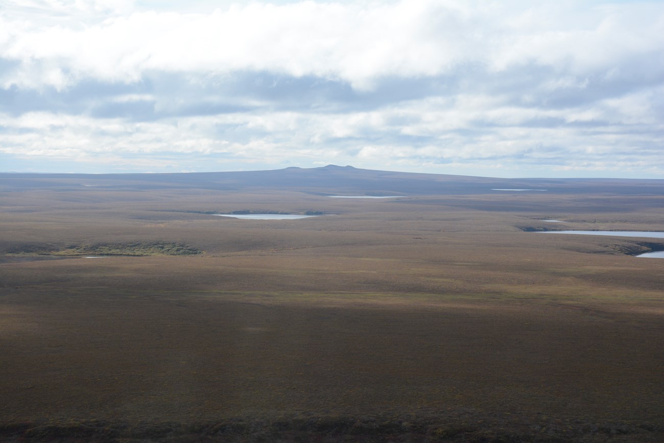 1632523170 photo of flat arctic landscape with several lakes and a broad mountain on the distant horizon