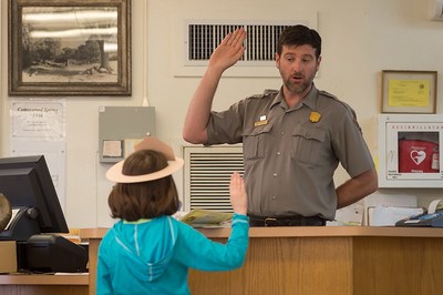 A ranger gives the pledge to a park visitor
