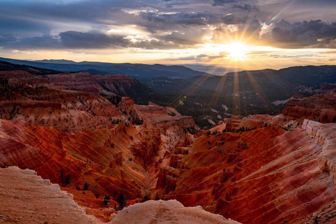 sunsetting over a red, sandstone canyon.