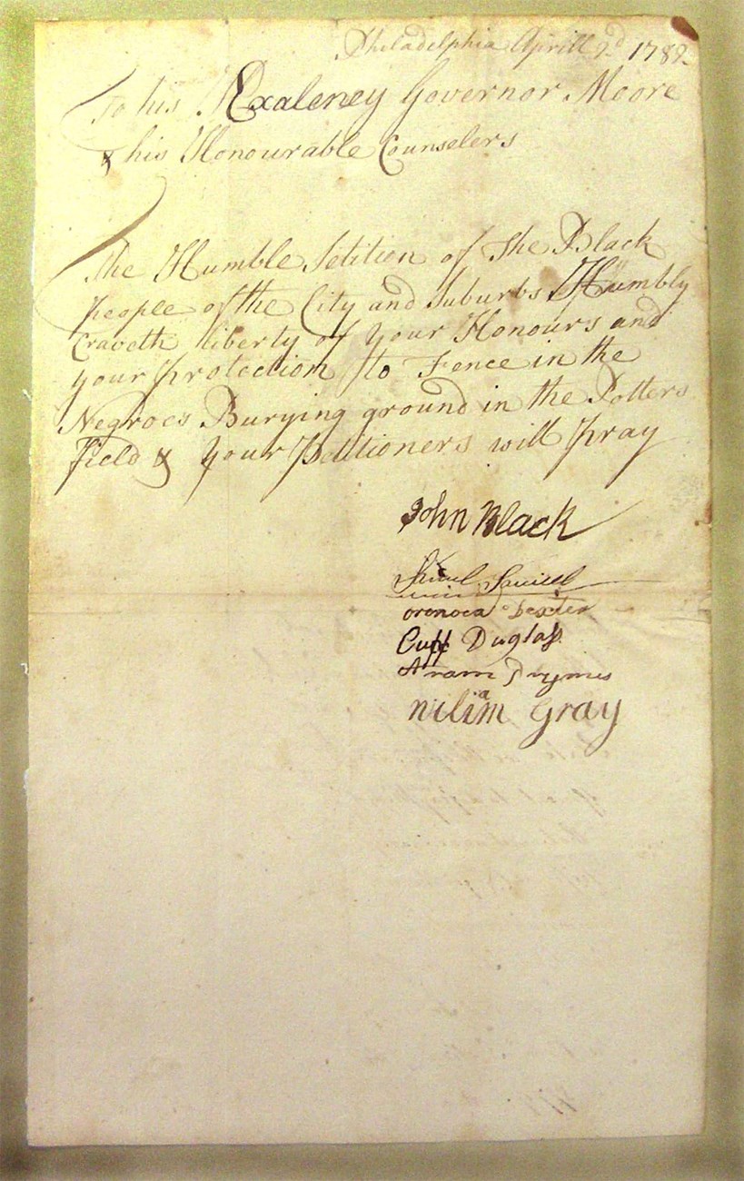Paper petition with dark ink on cream paper showing text and signatures.