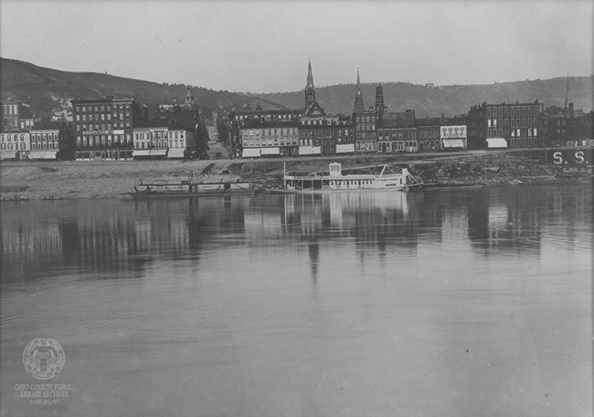 1886_Wheeling Wharf_24455422389_c13dc89b4e_o Black and white photograph showing wharf facilities and riverside buildings.