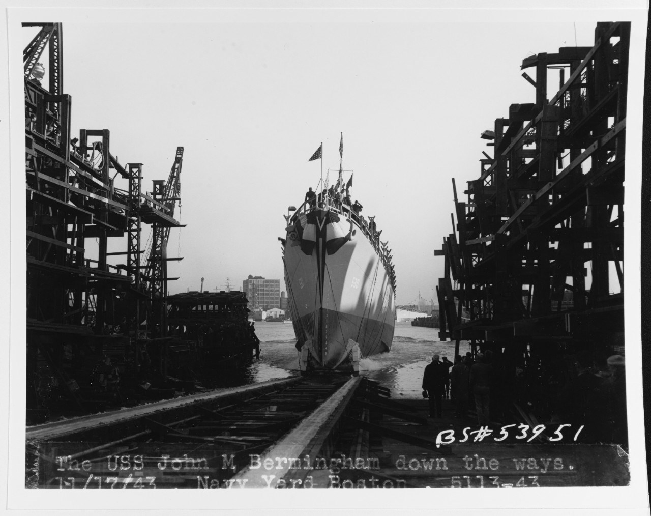 A destroyer escort sliding down a ramp into the water.