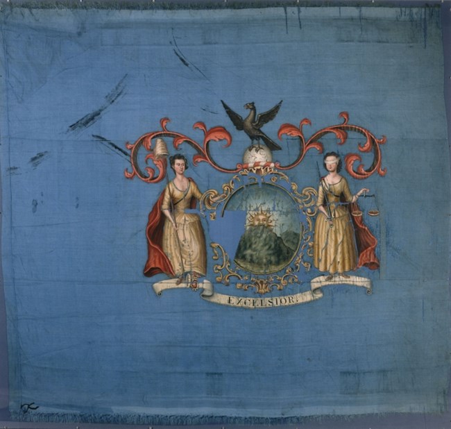A flag with two women dressed as Liberty and Justice, framing a shield with a harbor and ship on it.