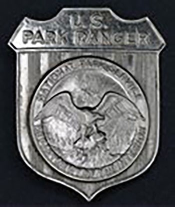 Shield badge with Round silver National Park Service badge with an eagle in the center.