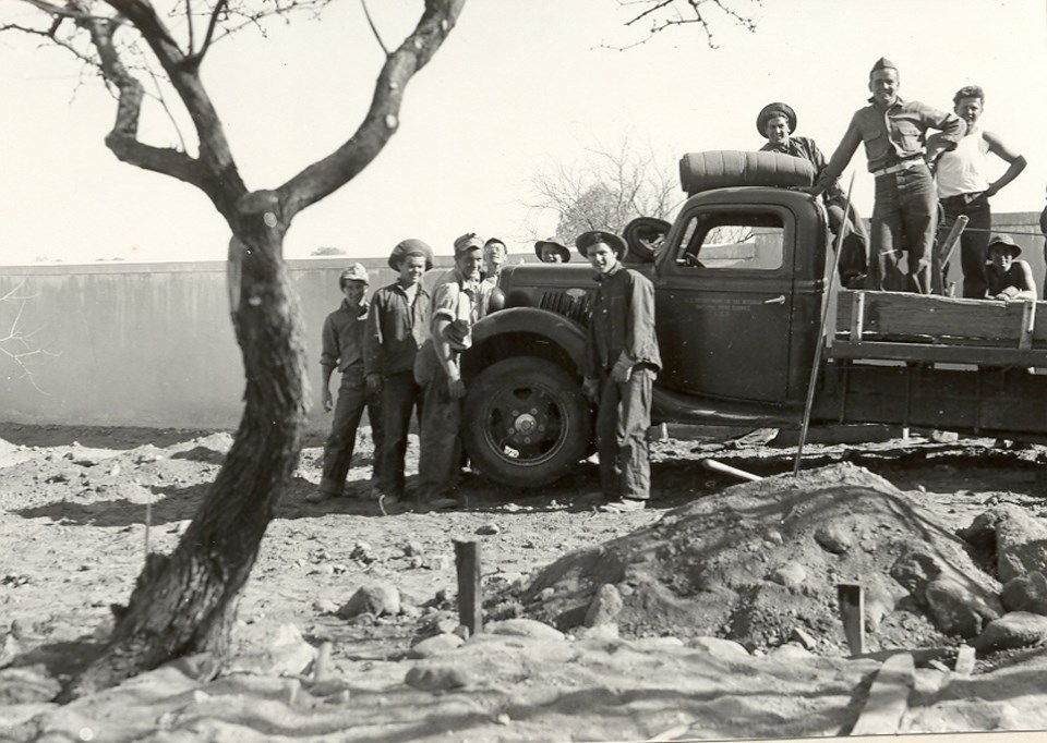 young men standing in truck inside garden walls