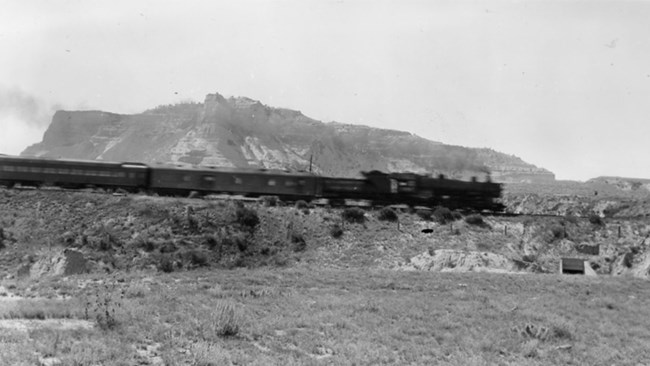 Union Pacific Railroad A steam engine makes its way past sandstone bluffs.