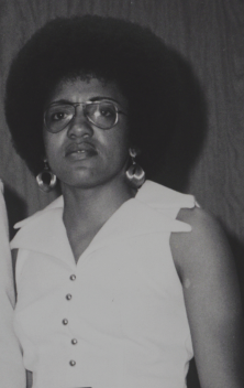Annie Simons, 1974 Annie Simons wearing a white sleeveless top.