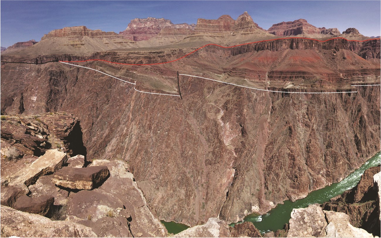 Photo of rocky cliffs and buttes with a line overlay highlighting a geologic contact.