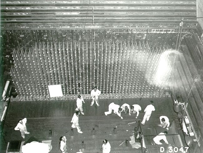 Black and white overhead view of workers in the reactor core