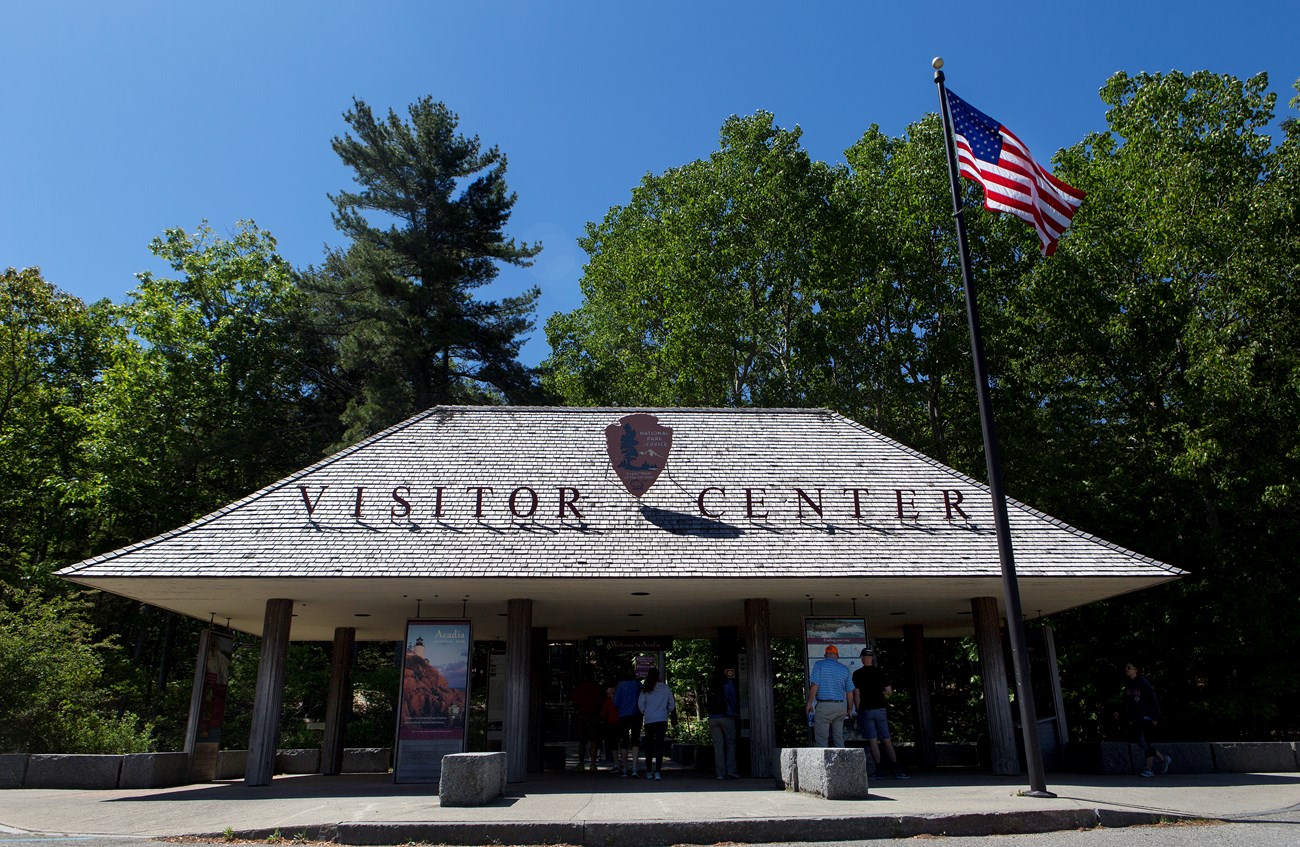 Pavilion entrance before Hulls Cove Visitor Center Pavilion with information displays next to a parking lot