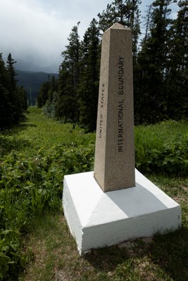 A border obelisk and a forest