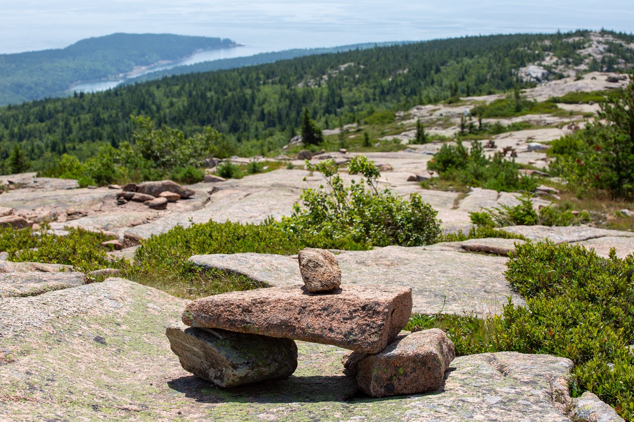 Cairn made of pink granite marking a trail along a ridgeline