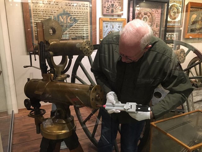 Photo of gentlemen examining historic machine gun