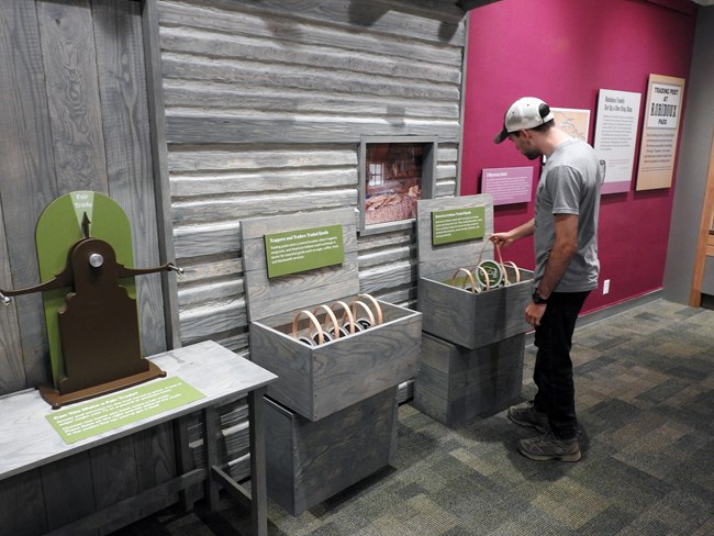 New Tactile Exhibit A visitor interacts with a tactile exhibit about trading posts.