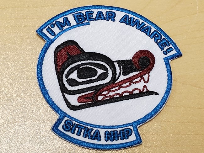 2022-03-31 Patch designed by Rhonda Reaney NPS photo Cinnamon Dockham A patch with a Tlingit formline bear design and the words "I'm Bear Aware"